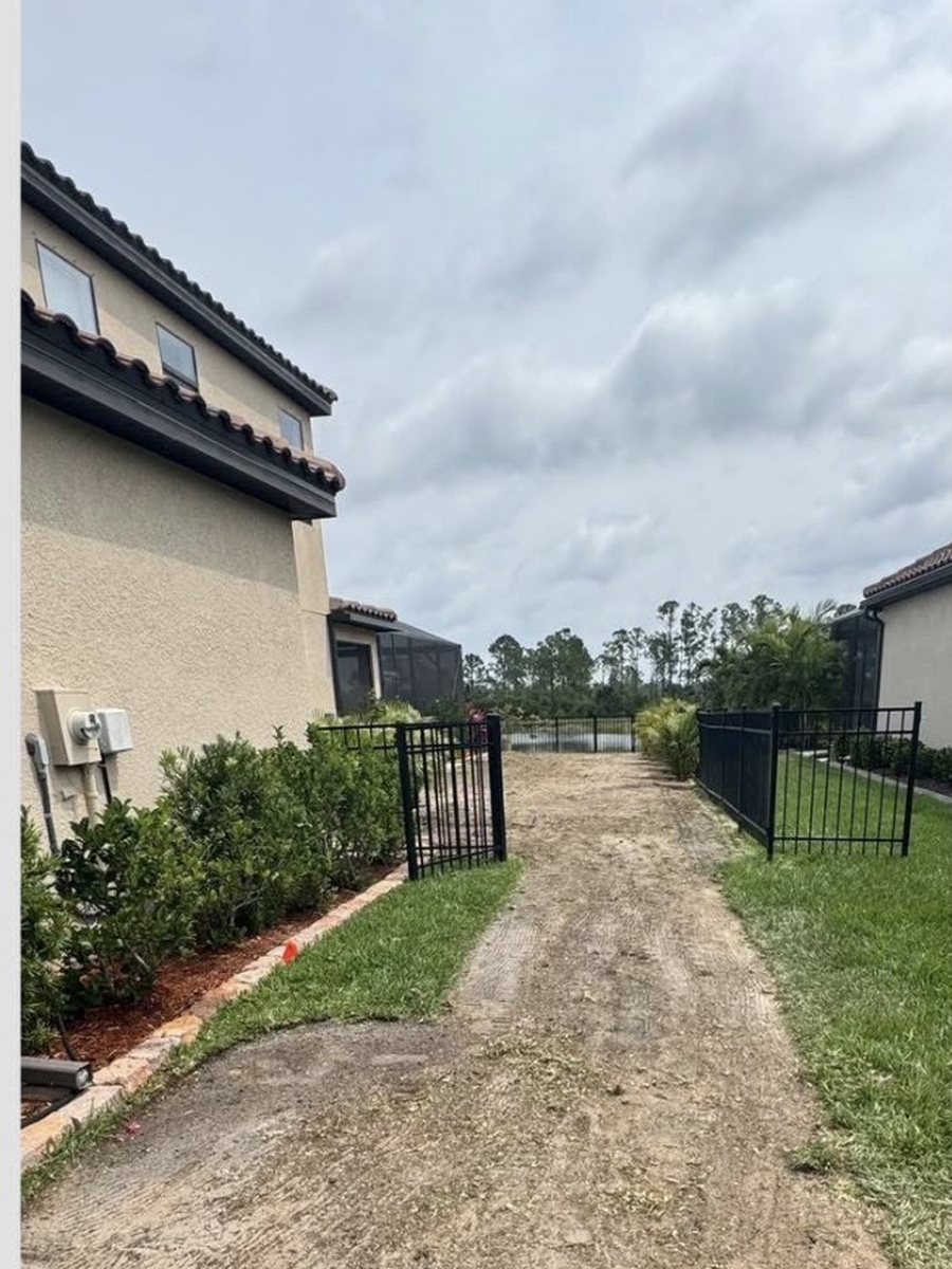 A bare sand side yard between two houses before sodding